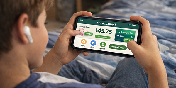 Young boy looking at greenlight account on phone
