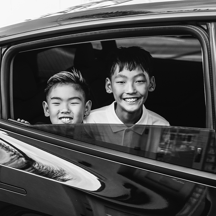 Two kids looking out car window