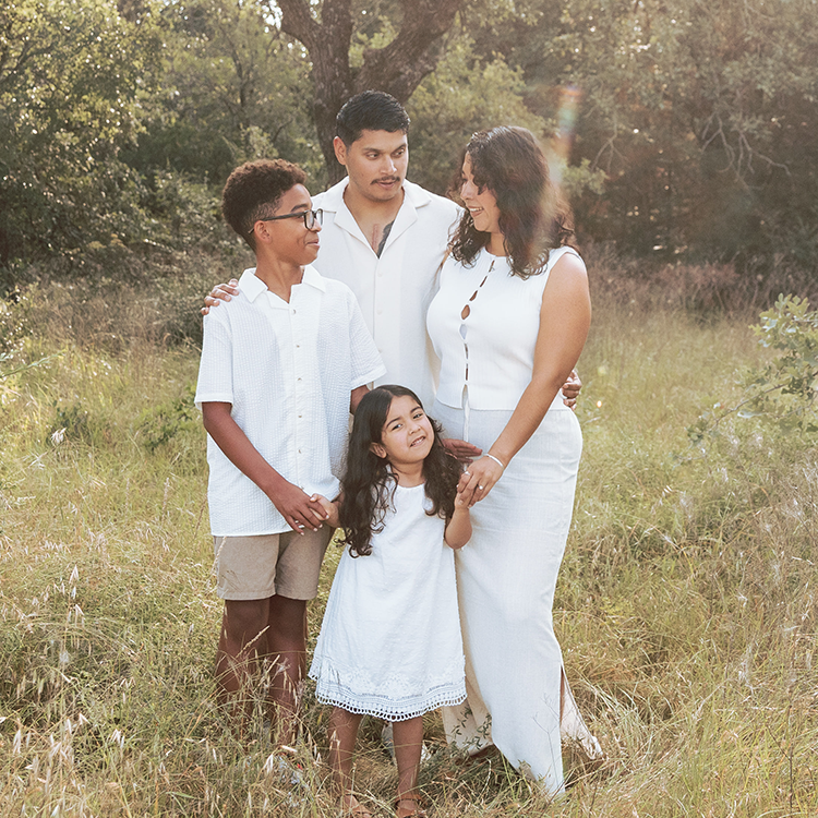 Family standing in the park long grass